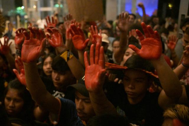 Brazilian natives from the Guarani ethnic group and environmental activists with their hands painted red protest against dredging in the Amazon in front of the headquarters of US agribusiness giant Cargill in Sao Paulo, Brazil, on February 20, 2026. (Photo by NELSON ALMEIDA / AFP)