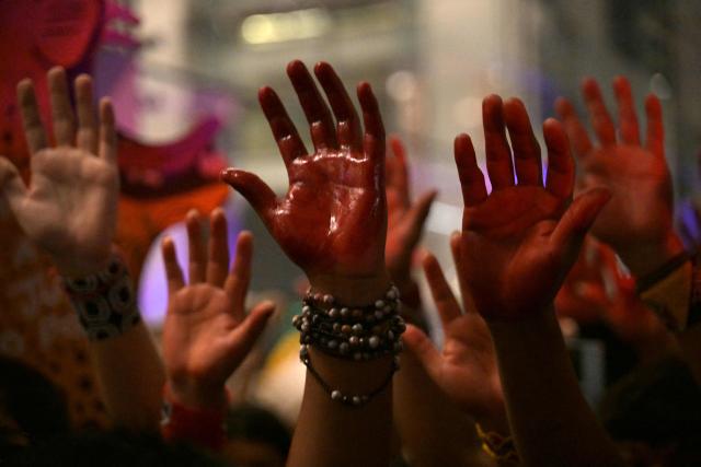 Brazilian natives from the Guarani ethnic group and environmental activists with their hands painted red protest against dredging in the Amazon in front of the headquarters of US agribusiness giant Cargill in Sao Paulo, Brazil, on February 20, 2026. (Photo by NELSON ALMEIDA / AFP)