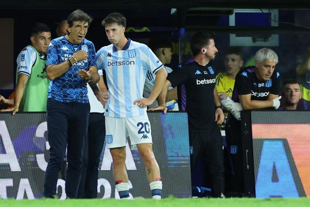 Racing's head coach Gustavo Costas (L) gives instructions to midfielder #20 Baltasar Rodriguez during the Argentine Professional Football League 2026 Apertura Tournament match between Boca Juniors and Racing at La Bombonera Stadium in Buenos Aires on February 20, 2026. (Photo by ALEJANDRO PAGNI / AFP)