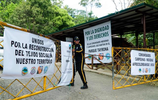 A security guard stands at the entrance of Tayrona National Park in the municipality of Santa Marta, Magdalena department, Colombia, on February 20, 2026. Defense Minister Pedro Sanchez said that extortion and pressure from ‘Los Pachenca’, a paramilitary group also known as the Conquistador Self-Defense Forces of the Sierra Nevada, forced the temporary closure of the park. (Photo by Randy Montenegro / AFP)