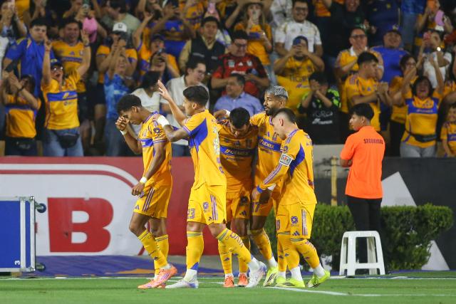 Tigres' forward #77 Ozziel Herrera (L) celebrates with teammates after scoring his team's first goal during the Liga MX Clausura football match between Tigres and Pachuca at the University Stadium (UANL) in Monterrey, Mexico, on February 20, 2026. (Photo by Julio Cesar AGUILAR / AFP)
