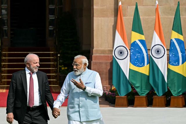 India's Prime Minister Narendra Modi (R) holds hands with Brazil's President Luiz Inacio Lula da Silva as they walk before their meeting at the Hyderabad House in New Delhi on February 21, 2026. (Photo by Sajjad HUSSAIN / AFP)