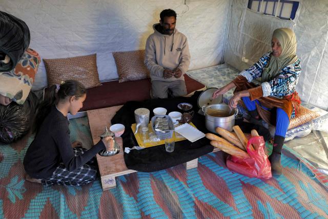 Members of a family sit to break their fast together for the "iftar" meal during the Muslim holy month of Ramadan in a tent shelter at a relief camp for those affected by floods that struck northern and western Morocco, in the Kenitra region on February 20, 2026. (Photo by Abdel Majid BZIOUAT / AFP)