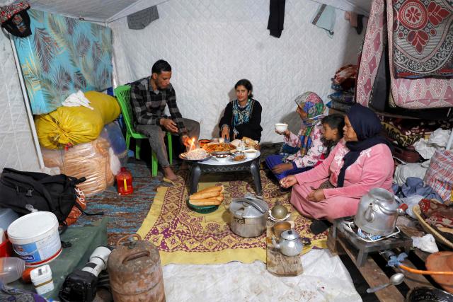 Members of a family sit to break their fast together for the "iftar" meal during the Muslim holy month of Ramadan in a tent shelter at a relief camp for those affected by floods that struck northern and western Morocco, in the Kenitra region on February 20, 2026. (Photo by Abdel Majid BZIOUAT / AFP)