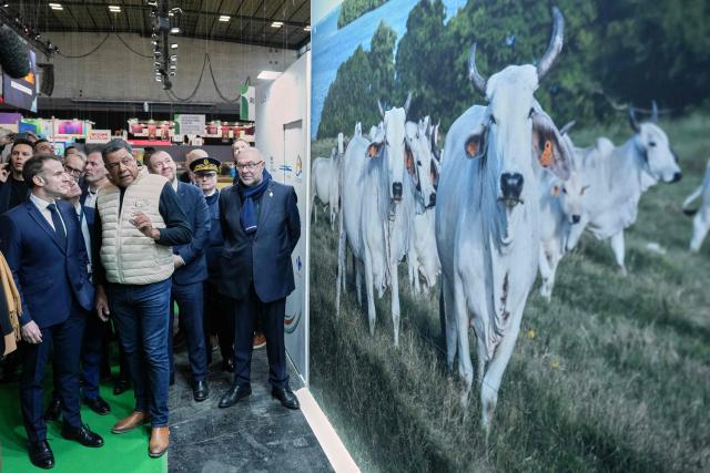 France's President Emmanuel Macron (L) talks to a farmer during the opening of the International Agriculture Fair (Salon de l'Agriculture) at Paris Expo Porte de Versailles, in Paris on February 21, 2026. (Photo by Aurelien Morissard / POOL / AFP)