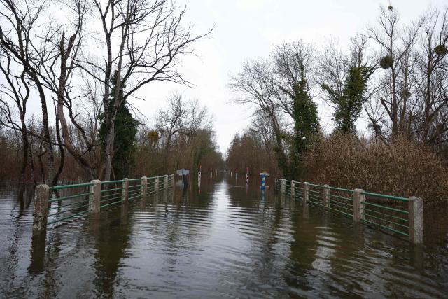 This photograph shows a flooded road in Courcoury southwestern France, on February 21, 2026. Météo-France has extended flood alerts for February 18 and February 19, 2026 : red for Loire-Atlantique, Charente-Maritime and Maine-et-Loire, and orange in nine other departments in the west, while noting that the dry weather should help the waters recede. (Photo by ROMAIN PERROCHEAU / AFP)