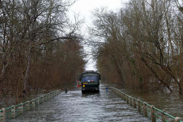 An elevated vehicle of the French Gendarmerie drives in a flooded road in Courpignac, south-western France on February 21, 2026, while taking part in a rescue operation to evacuate isolated residents. Météo-France has extended flood alerts for February 18 and February 19, 2026 : red for Loire-Atlantique, Charente-Maritime and Maine-et-Loire, and orange in nine other departments in the west, while noting that the dry weather should help the waters recede. (Photo by ROMAIN PERROCHEAU / AFP)