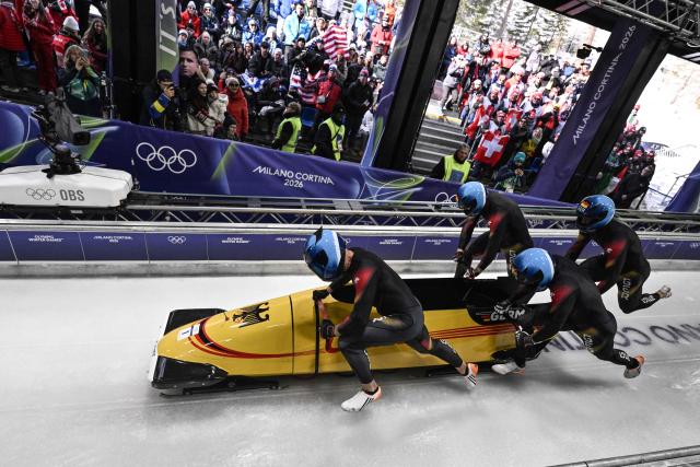 Germany's Johannes Lochner, Germany's Thorsten Margis, Germany's Jorn Wenzel and Germany's Georg Fleischhauer compete in  the bobsleigh men's 4-man heat 1 at Cortina Sliding Centre during the Milano Cortina 2026 Winter Olympic Games in Cortina d'Ampezzo on February 21, 2026. (Photo by Tiziana FABI / AFP)
