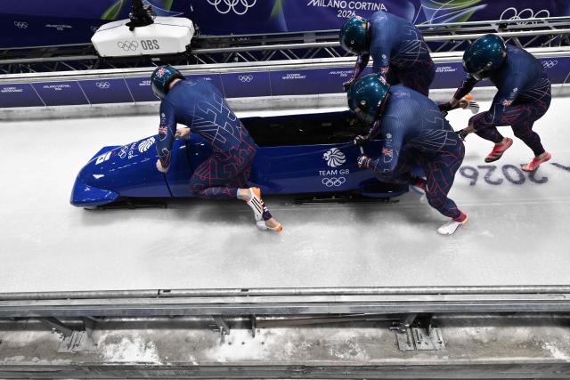 Britain's Brad Hall, Britain's Greg Cackett, Britain's Leon Greenwood and Britain's Taylor Lawrence compete in the bobsleigh men's 4-man heat 1 at Cortina Sliding Centre during the Milano Cortina 2026 Winter Olympic Games in Cortina d'Ampezzo on February 21, 2026. (Photo by Tiziana FABI / AFP)