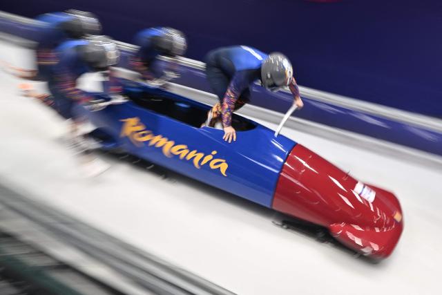 Romania's Mihai Cristian Tentea, Romania's Mihai Daniel Pacioianu, Romania's George Iordache and Romania's Constantin Dinescu compete in  the bobsleigh men's 4-man heat 1 at Cortina Sliding Centre during the Milano Cortina 2026 Winter Olympic Games in Cortina d'Ampezzo on February 21, 2026. (Photo by Tiziana FABI / AFP)