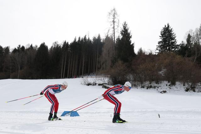 Norway's Johannes Hoesflot Klaebo (L) and Norway's Martin Loewstroem Nyenget compete during the men's cross country 50km mass start final event of the Milano Cortina 2026 Winter Olympic Games at Tesero Cross-Country Skiing Stadium in Lago di Tesero (Val di Fiemme) on February 21, 2026. (Photo by Anne-Christine POUJOULAT / AFP)