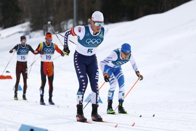 USA's Gus Schumacher (C) competes during the men's cross country 50km mass start final event of the Milano Cortina 2026 Winter Olympic Games at Tesero Cross-Country Skiing Stadium in Lago di Tesero (Val di Fiemme) on February 21, 2026. (Photo by Anne-Christine POUJOULAT / AFP)