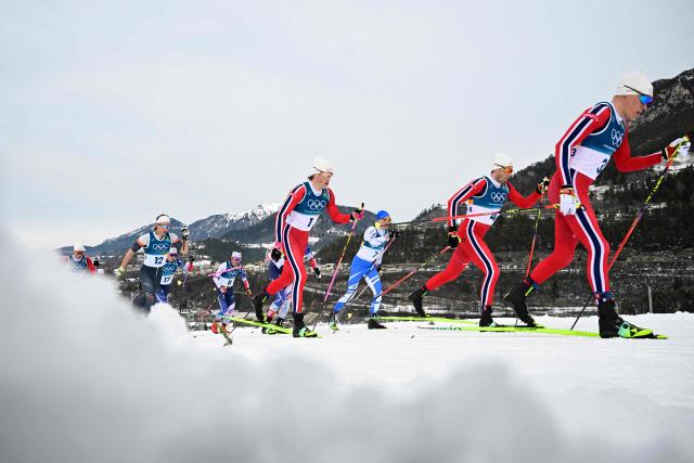 (From R) Norway's Martin Loewstroem Nyenget, Norway's Emil Iversen, Finland's Iivo Niskanen, Norway's Johannes Hoesflot Klaebo, France's Hugo Lapalus and Individual Neutral Athlete Savelii Korostelev compete during the men's cross country 50km mass start final event of the Milano Cortina 2026 Winter Olympic Games at Tesero Cross-Country Skiing Stadium in Lago di Tesero (Val di Fiemme) on February 21, 2026. (Photo by Tobias SCHWARZ / AFP)