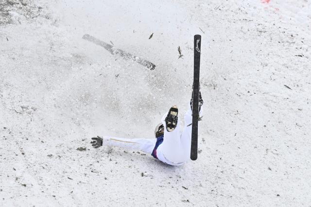 China's Wang Xindi tumbles upon landing as he competes in the freestyle skiing mixed team aerials final 2 during the Milano Cortina 2026 Winter Olympic Games at Livigno Aerials & Moguls Park, in Livigno (Valtellina), on February 21, 2026. (Photo by Jeff PACHOUD / AFP)