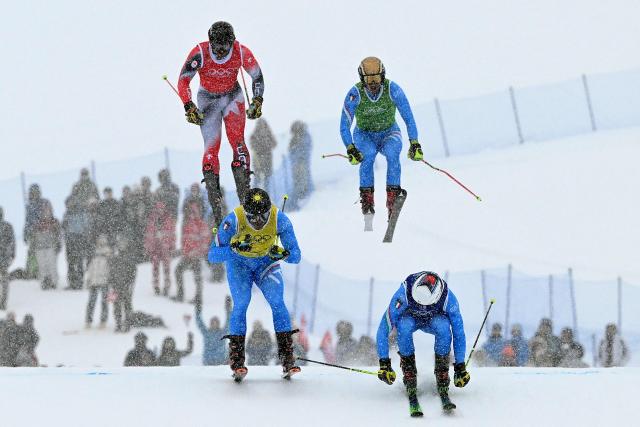 (From L) Canada's Reece Howden, Italy's Federico Tomasoni, Italy's Dominik Zuech and Italy's Simone Deromedis compete in the freestyle skiing men's ski cross quarter final during the Milano Cortina 2026 Winter Olympic Games at Livigno Snow Park, in Livigno (Valtellina), on February 21, 2026. (Photo by Kirill KUDRYAVTSEV / AFP)