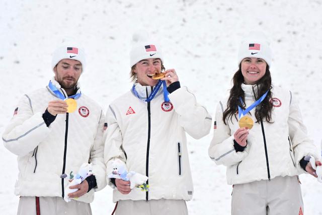 (From L)Gold medallists USA's Christopher Lillis, USA's Connor Curran and USA's Kaila Kuhn celebrate on the podium after the freestyle skiing mixed team aerials final during the Milano Cortina 2026 Winter Olympic Games at Livigno Aerials & Moguls Park, in Livigno (Valtellina), on February 21, 2026. (Photo by Jeff PACHOUD / AFP)