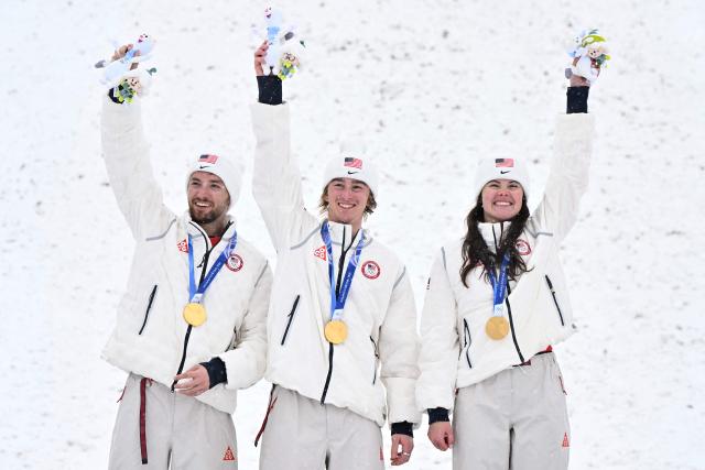 (From L)Gold medallists USA's Christopher Lillis, USA's Connor Curran and USA's Kaila Kuhn celebrate on the podium after the freestyle skiing mixed team aerials final during the Milano Cortina 2026 Winter Olympic Games at Livigno Aerials & Moguls Park, in Livigno (Valtellina), on February 21, 2026. (Photo by Jeff PACHOUD / AFP)