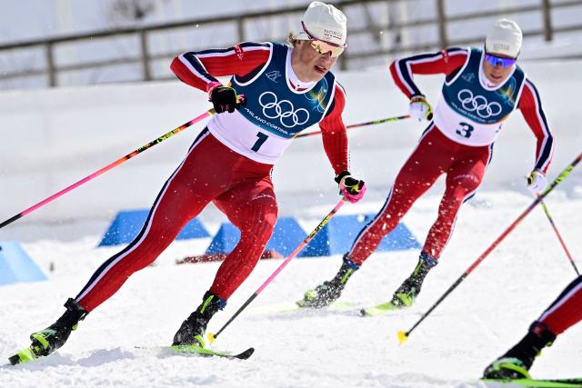 Norway's Johannes Hoesflot Klaebo (L) and Norway's Martin Loewstroem Nyenget compete during the men's cross country 50km mass start final event of the Milano Cortina 2026 Winter Olympic Games at Tesero Cross-Country Skiing Stadium in Lago di Tesero (Val di Fiemme) on February 21, 2026. (Photo by Tobias SCHWARZ / AFP)