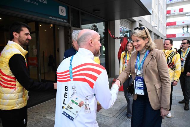 Queen Mathilde of Belgium (R) is welcomed by Olav Spahl, head of Belgian delegation, before a visit to the Olympic Village during the Milano Cortina 2026 Winter Olympics in Milan on February 21, 2026. (Photo by Daniel MUNOZ / POOL / AFP)