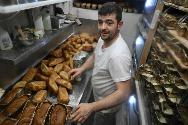 French volunteer baker Loic Nervi prepares freshly baked bread in his mobile bakery to distribute among residents of a temporary dwelling for people who lost their homes and internally displaced people in Borodyanka, Kyiv region on February 19, 2026, amid the Russian invasion of Ukraine. While Ukraine regularly faces power and heating cuts due to Russian strikes, Loic Nervi
works alone from early morning to bake around 700 loaves of bread a day, attracting dozens of locals to his white truck. Over multiple missions across Ukraine, he says he has distributed tens of thousands of loaves, most often to elderly residents left without family support. (Photo by Genya SAVILOV / AFP)