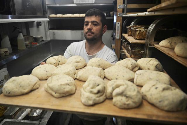 French volunteer baker Loic Nervi bakes bread in his mobile bakery to distribute among residents of a temporary dwelling for people who lost their homes and internally displaced people in Borodyanka, Kyiv region on February 19, 2026, amid the Russian invasion of Ukraine. While Ukraine regularly faces power and heating cuts due to Russian strikes, Loic Nervi
works alone from early morning to bake around 700 loaves of bread a day, attracting dozens of locals to his white truck. Over multiple missions across Ukraine, he says he has distributed tens of thousands of loaves, most often to elderly residents left without family support. (Photo by Genya SAVILOV / AFP)
