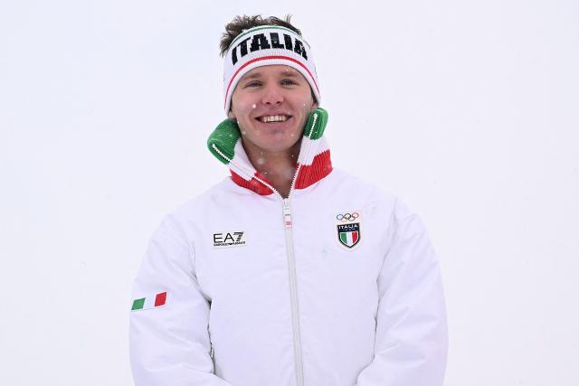 Gold medallist Italy's Simone Deromedis poses on the podium after the freestyle skiing men's ski cross final during the Milano Cortina 2026 Winter Olympic Games at Livigno Snow Park, in Livigno (Valtellina), on February 21, 2026. (Photo by Kirill KUDRYAVTSEV / AFP)