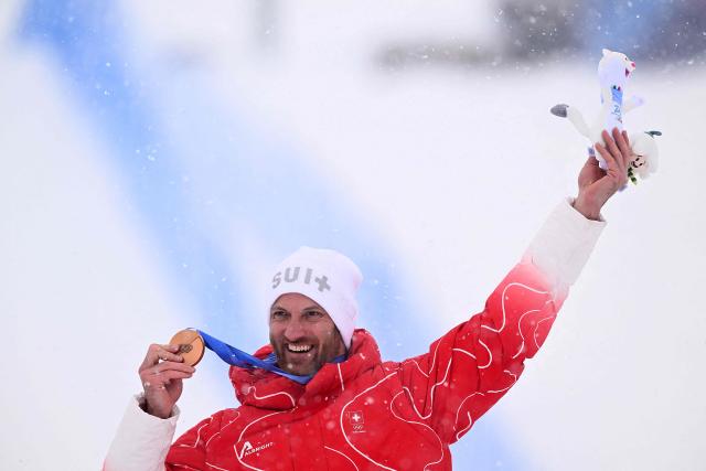Bronze medallist Switzerland's Alex Fiva poses on the podium after the freestyle skiing men's ski cross final during the Milano Cortina 2026 Winter Olympic Games at Livigno Snow Park, in Livigno (Valtellina), on February 21, 2026. (Photo by Kirill KUDRYAVTSEV / AFP)