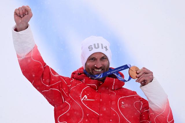 Bronze medallist Switzerland's Alex Fiva poses on the podium after the freestyle skiing men's ski cross final during the Milano Cortina 2026 Winter Olympic Games at Livigno Snow Park, in Livigno (Valtellina), on February 21, 2026. (Photo by Kirill KUDRYAVTSEV / AFP)
