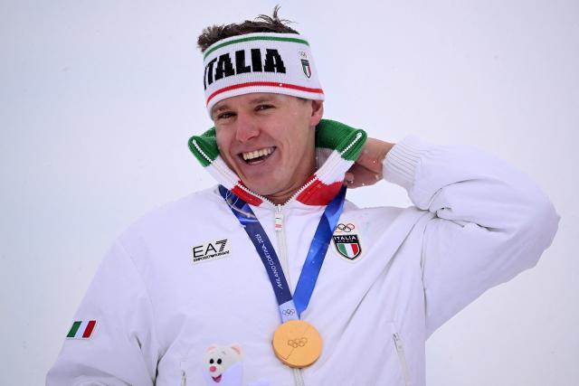 Gold medallist Italy's Simone Deromedis poses on the podium after the freestyle skiing men's ski cross final during the Milano Cortina 2026 Winter Olympic Games at Livigno Snow Park, in Livigno (Valtellina), on February 21, 2026. (Photo by Kirill KUDRYAVTSEV / AFP)