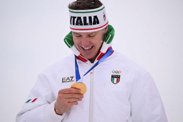 Gold medallist Italy's Simone Deromedis poses on the podium after the freestyle skiing men's ski cross final during the Milano Cortina 2026 Winter Olympic Games at Livigno Snow Park, in Livigno (Valtellina), on February 21, 2026. (Photo by Kirill KUDRYAVTSEV / AFP)
