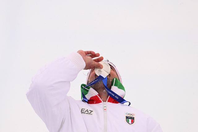 Silver medallist Italy's Federico Tomasoni kisses his medal on the podium after the freestyle skiing men's ski cross final during the Milano Cortina 2026 Winter Olympic Games at Livigno Snow Park, in Livigno (Valtellina), on February 21, 2026. (Photo by Kirill KUDRYAVTSEV / AFP)