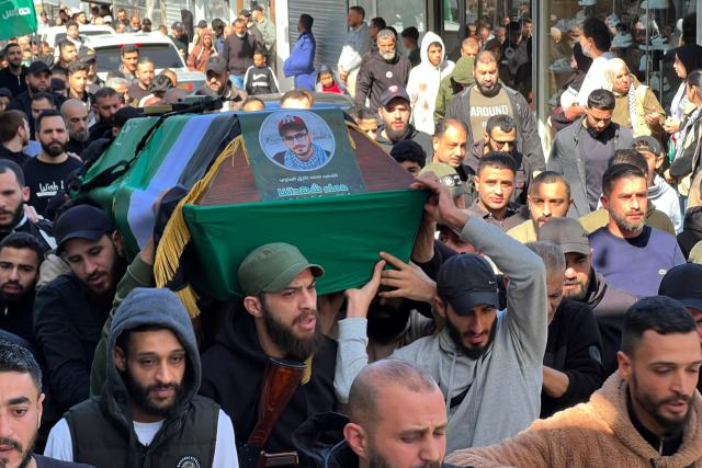 Mourners carry one of two coffins, the day after two people were killed in an Israeli strike on the Palestinian refugee camp in Ain al-Hilweh, near the coastal city of Sidon, in southern Lebanon on February 21, 2026. Lebanon's health ministry said 10 people were killed on February 20, 2026, in the east and two in the south of the country both areas where Hezbollah holds sway. The strikes come as tensions are brewing between the United States and Iran, with the US president threatening military action over the Islamic republic's nuclear programme. (Photo by Mahmoud ZAYYAT / AFP)