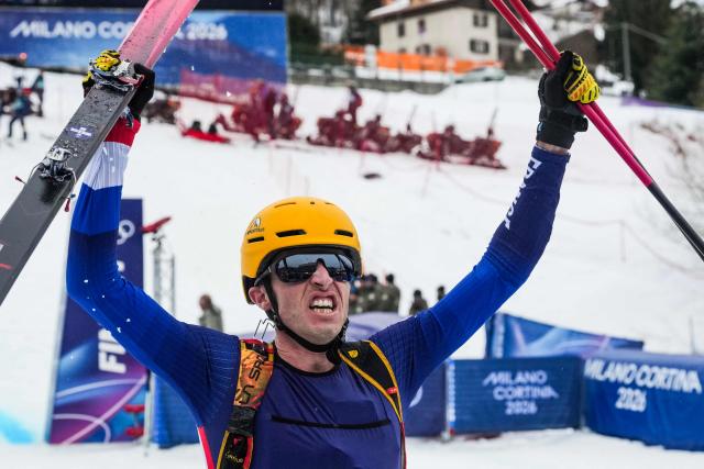 France's Thibault Anselmet celebrates after winning in the mixed relay ski mountaineering race during the Milano Cortina 2026 Winter Olympic Games at the Stelvio Ski Centre in Bormio (Valtellina) on February 21, 2026. (Photo by Dimitar DILKOFF / AFP)