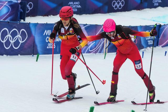 Spain's Oriol Cardona Coll (R) hands over to Spain's Ana Alonso Rodriguez ast they compete in the mixed relay ski mountaineering race during the Milano Cortina 2026 Winter Olympic Games at the Stelvio Ski Centre in Bormio (Valtellina) on February 21, 2026. (Photo by Dimitar DILKOFF / AFP)