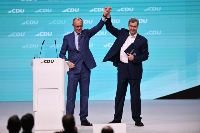 Germany's Chancellor Friedrich Merz and Bavaria's State Premier and leader of the conservative Christian Social Union (CSU) Markus Soeder react on stage during the party congress of Germany's Christian Democratic Union (CDU) in Stuttgart, southern Germany, on February 21, 2026. (Photo by THOMAS KIENZLE / AFP)