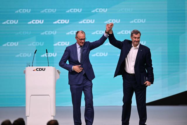 Germany's Chancellor Friedrich Merz and Bavaria's State Premier and leader of the conservative Christian Social Union (CSU) Markus Soeder react on stage during the party congress of Germany's Christian Democratic Union (CDU) in Stuttgart, southern Germany, on February 21, 2026. (Photo by THOMAS KIENZLE / AFP)