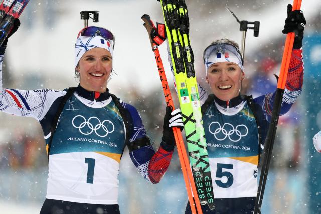 France's Oceane Michelon (R) celebrates after winning gold and France's Julia Simon celebrates her silver after the women's biathlon 12.5km mass start event during the Milano Cortina 2026 Winter Olympic Games at the Anterselva Biathlon Arena (Sudtirol Arena) in Anterselva (Val Pusteria) on February 21, 2026. (Photo by FRANCK FIFE / AFP)