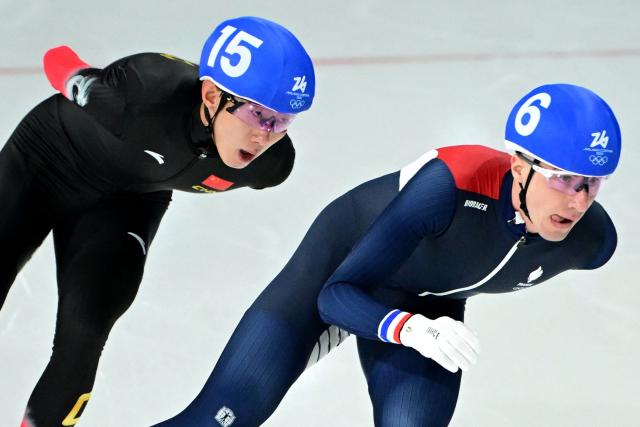 China's Wu Yu and France's Timothy Loubineaud compete in the speed skating men's mass start semi-final during the Milano Cortina 2026 Winter Olympic Games at Milano Speed Skating Stadium in Milan on February 21, 2026. (Photo by Piero CRUCIATTI / AFP)