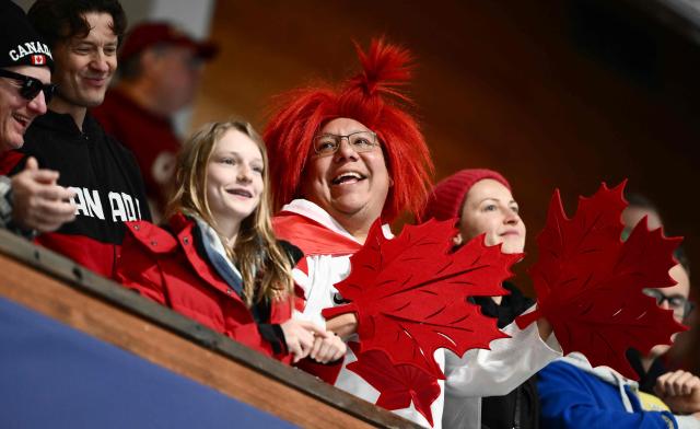 Canada fans watch the curling women's round robin bronze medal game between Canada and USA during the Milano Cortina 2026 Winter Olympic Games at the Cortina Curling Olympic Stadium in Cortina d’Ampezzo on February 21, 2026. (Photo by Marco BERTORELLO / AFP)