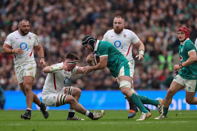 Ireland's number 8 Caelan Doris (C) knocks over England's flanker Tom Curry (2nd L) during the Six Nations international rugby union match between England and Ireland at Allianz Stadium, Twickenham, in south-west London, on February 21, 2026. (Photo by Adrian Dennis / AFP)