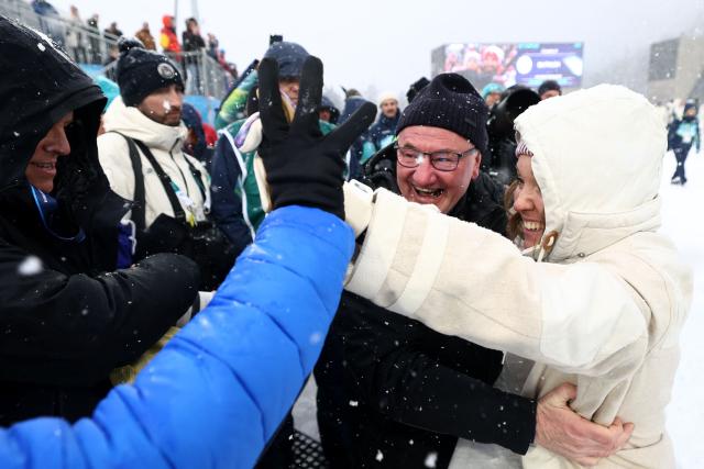 Gold medallist France's Oceane Michelon (R) celebrates with supporters after the victory ceremony of the women's biathlon 12.5km mass start event during the Milano Cortina 2026 Winter Olympic Games at the Anterselva Biathlon Arena (Sudtirol Arena) in Anterselva (Val Pusteria) on February 21, 2026. (Photo by Franck FIFE / AFP)
