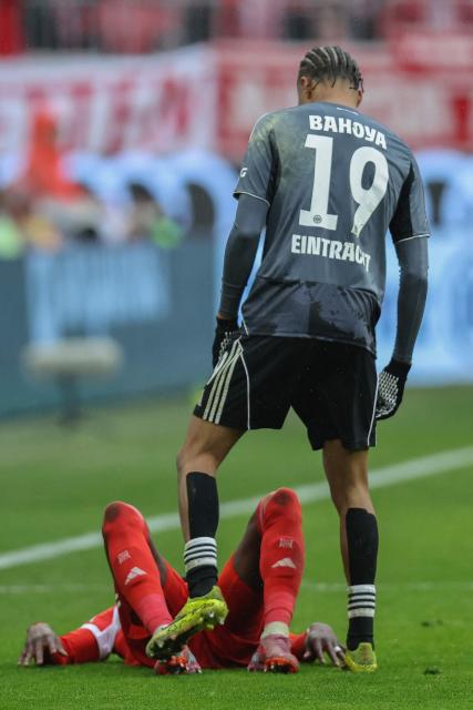 Bayern Munich's Canadian defender #19 Alphonso Davies (R) was fouled by Frankfurt's French forward #19 Jean-Matteo Bahoya during the German first division Bundesliga football match between FC Bayern Munich and Eintracht Frankfurt in Munich, southern Germany, on February 21, 2026. (Photo by Alexandra BEIER / AFP) / DFL REGULATIONS PROHIBIT ANY USE OF PHOTOGRAPHS AS IMAGE SEQUENCES AND/OR QUASI-VIDEO