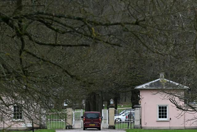 A police vehicle passes through the gated entrance to Royal Lodge, a 30-room property and former residence to Britain's former prince Andrew where police said they are still conducting a search, in Windsor, west of London on February 21, 2026, after Britain's former prince Andrew was arrested on February 19. The British government on February 20 mulled passing a law to remove former prince Andrew from the line of succession, as police stepped up investigations into his conduct, quizzing the disgraced royal's former protection officers. (Photo by JUSTIN TALLIS / AFP)