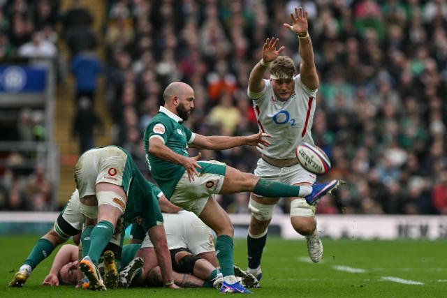Ireland's scrum-half Jamison Gibson-Park (C) clears the ball as England's Alex Coles (R) charges in during the Six Nations international rugby union match between England and Ireland at Allianz Stadium, Twickenham, in south-west London, on February 21, 2026. (Photo by Glyn KIRK / AFP)