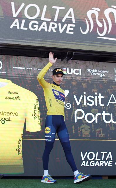 Lidl-Trek Spanish cyclist Juan Ayuso celebrates on the podium reatainig the overall ranking leader's yellow jersey after the stage four of the Algarve Tour, a 182.10 km race from Albufeira to Lagos, on February 21, 2026. (Photo by João Matos / AFP)