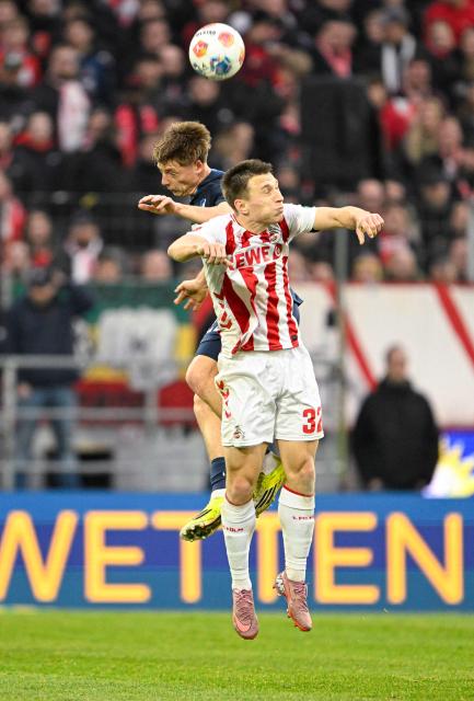 Hoffenheim's Austrian midfielder #22 Alexander Prass (Back) and FC Cologne's US defender #32 Kristoffer Lund vie for the ball during the German first division Bundesliga football match 1 FC Cologne v TSG 1899 Hoffenheim in Cologne, western Germany, on February 21, 2026. (Photo by INA FASSBENDER / AFP) / DFL REGULATIONS PROHIBIT ANY USE OF PHOTOGRAPHS AS IMAGE SEQUENCES AND/OR QUASI-VIDEO