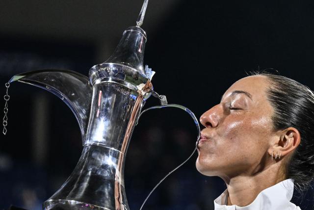 US' Jessica Pegula celebrates with the trophy after winning her women’s singles final match against Ukraine's Elina Svitolina at the Dubai Duty Free Tennis tournament in Dubai on February 21, 2026. (Photo by Ryan Lim / AFP)