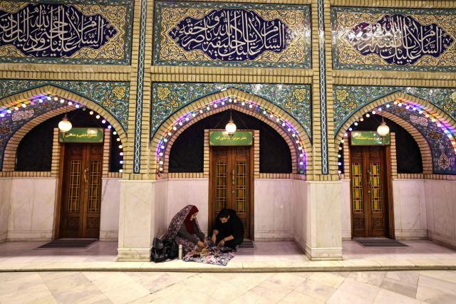 An Iranian couple break the dawn to dusk Ramadan fast during Iftar, in the grounds of the Imamzadeh Saleh mosque in Tehran on February 21, 2026. Muslims throughout the world are marking the month of Ramadan, the holiest month in the Islamic calendar, during which devotees fast from dawn until dusk. (Photo by ATTA KENARE / AFP)