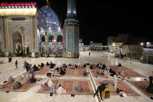 Iranian families sits together to break the dawn to dusk Ramadan fast during Iftar, in the grounds of the Imamzadeh Saleh mosque in Tehran on February 21, 2026. Muslims throughout the world are marking the month of Ramadan, the holiest month in the Islamic calendar, during which devotees fast from dawn until dusk. (Photo by ATTA KENARE / AFP)