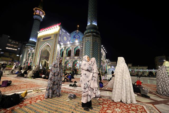 Iranian women recites a prayer just before iftar and the breaking of the dawn to dusk Ramadan fast, in the grounds of the Imamzadeh Saleh mosque in Tehran on February 21, 2026. Muslims throughout the world are marking the month of Ramadan, the holiest month in the Islamic calendar, during which devotees fast from dawn until dusk. (Photo by ATTA KENARE / AFP)